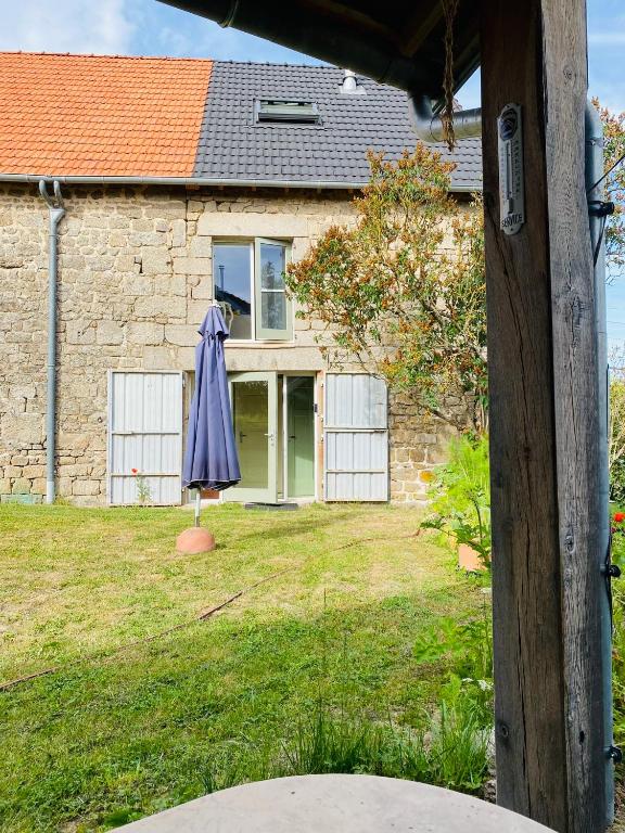 an umbrella in the yard of a house at Au Petit Paradis in Saint-Domet