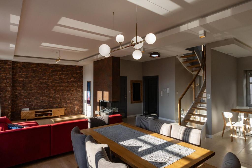 a living room with a dining table and a brick wall at KAJKl 15 in Lidzbark Warmiński