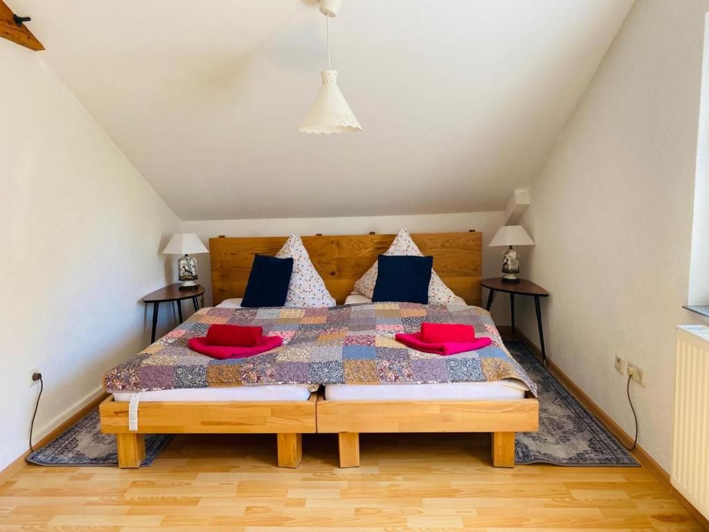 a bedroom with a bed with red pillows on it at Klosterherberge Economy in Meßkirch