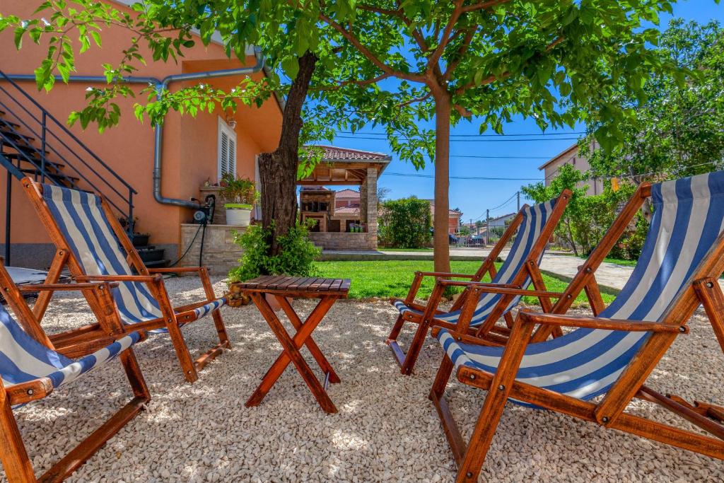 a group of chairs sitting in front of a house at Bella Casa in Sukošan