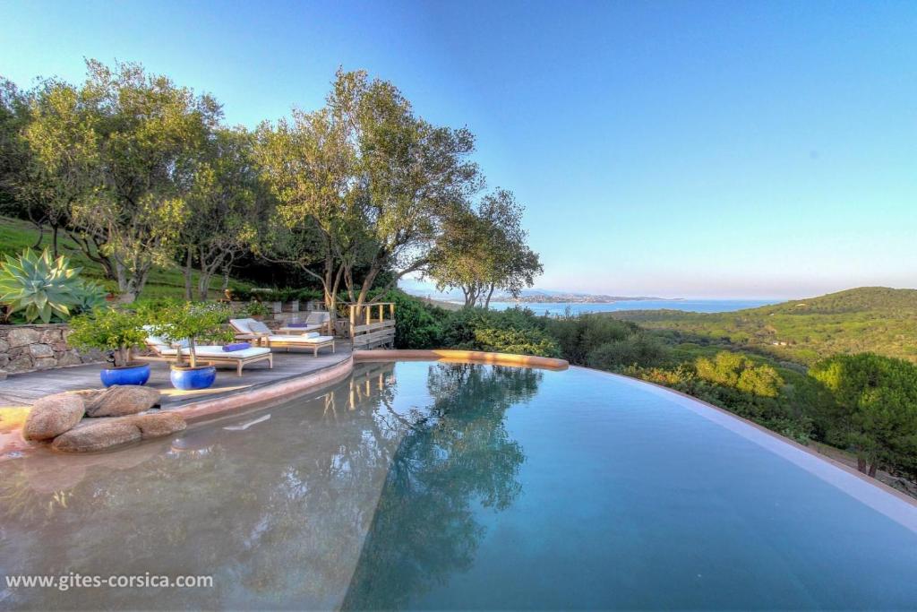 a swimming pool with a view of the hills at Casa penisula in Porto-Vecchio