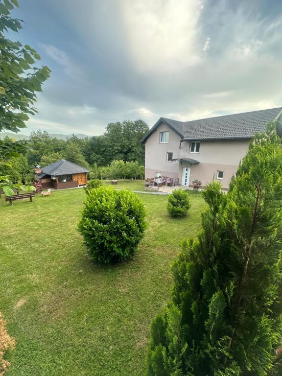 a house with a yard with trees and bushes at Hil in Rakovica
