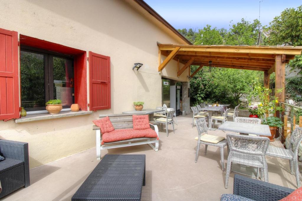 an outdoor patio with tables and chairs and awning at Couvent d'alando in Alando