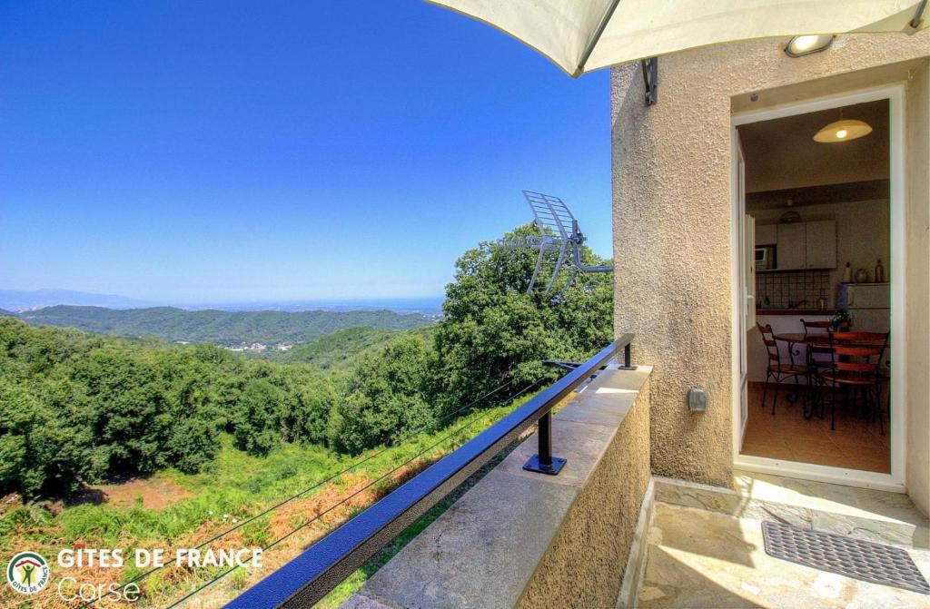 a house with a balcony with a view of the mountains at Mezzana in Taglio-Isolaccio