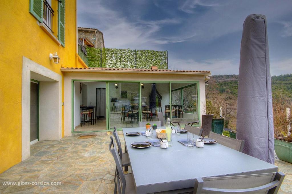 a table and chairs on the patio of a house at Casa di l'apa in Venaco