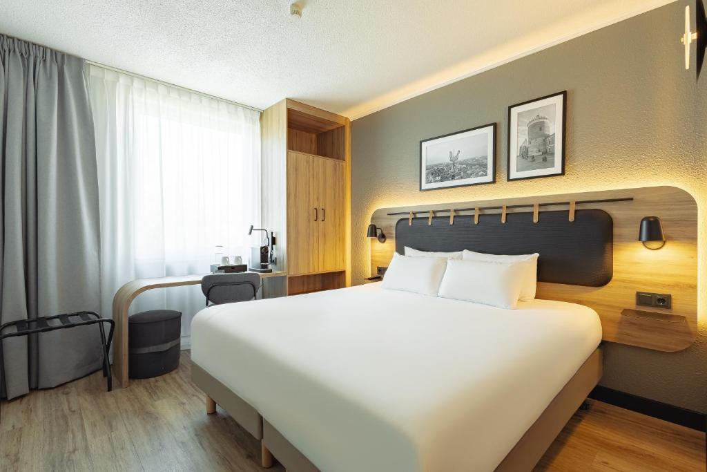 a hotel room with a large bed and a desk at Campanile PRIME - Lublin in Lublin