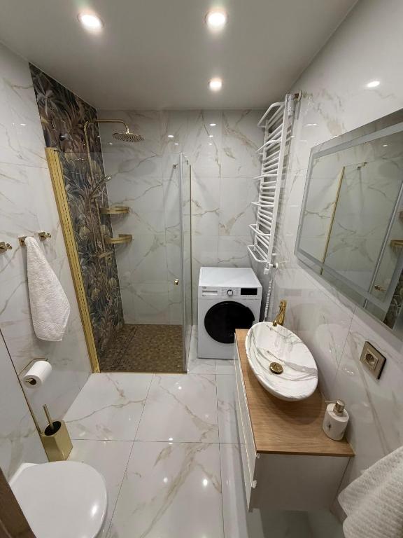 a bathroom with a shower and a toilet and a sink at Anuszka Apartament 3 in Gdynia