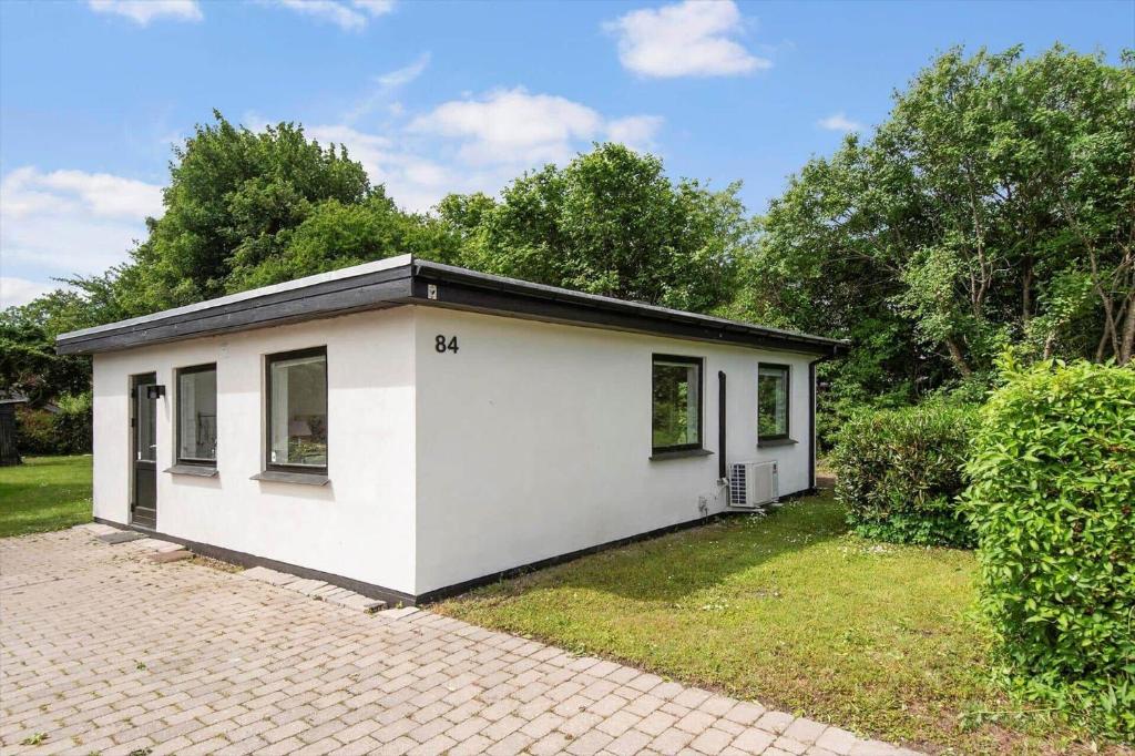 a small white house in a yard at S754-Stroby-Ladeplads-Svalemosevej-84 in Strøby Ladeplads