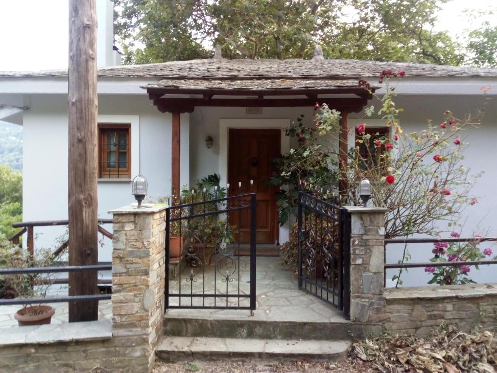 a small white house with a black gate at Δάσος ΜΕ ΠΛΑΤΑΝΙΑ in Agios Dimitrios