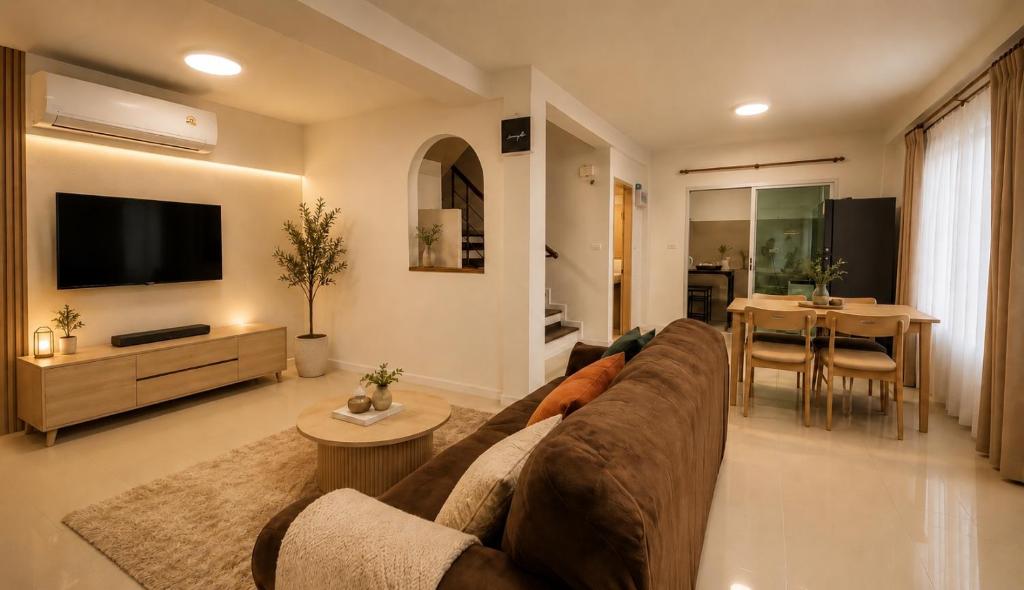 a living room with a couch and a table at City Hill Residence in Ban Khok Chang