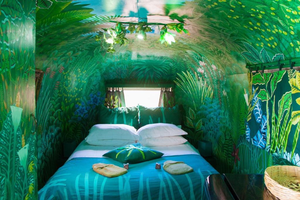 sypialnia z łóżkiem w pokoju urządzonym w stylu dżungli w obiekcie Old Mac Daddy w mieście Botrivier