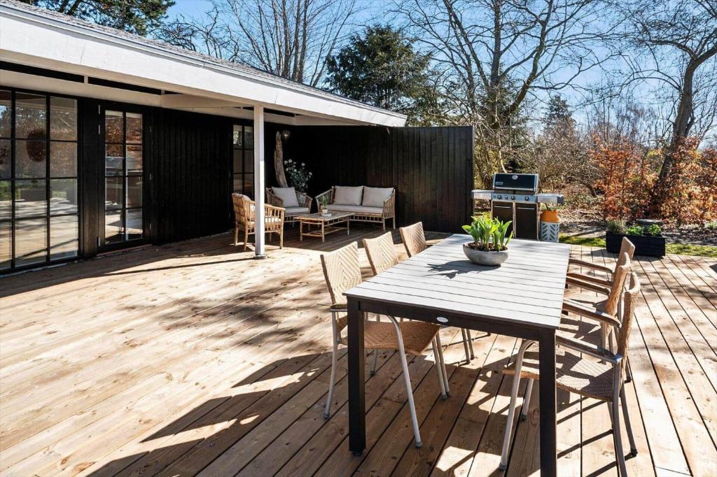 a wooden table and chairs on a wooden deck at 1087-Stege-Berberisvej-7 in Stege