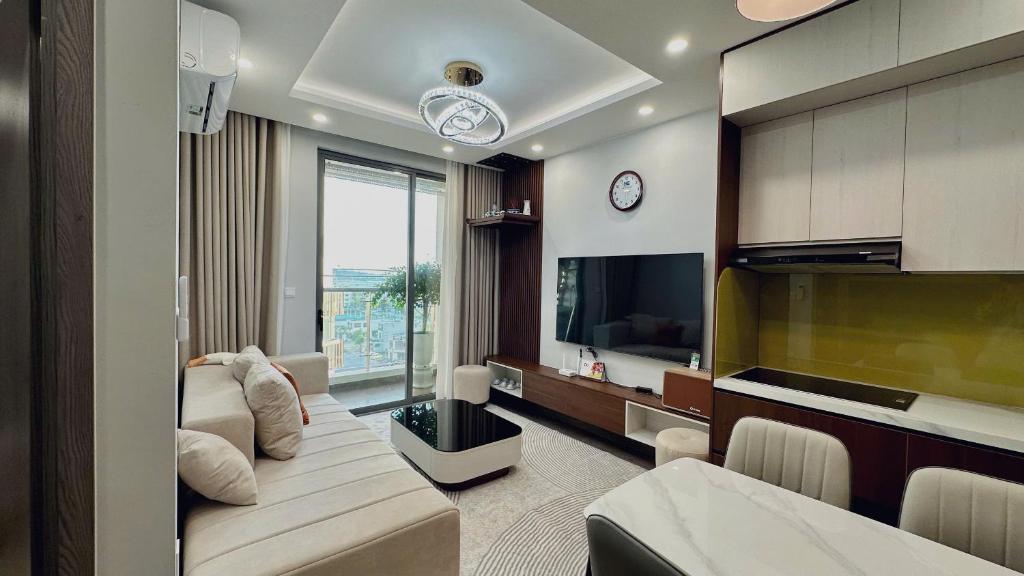 a living room with a couch and a tv at Ruby's Home The Ruby Hạ Long in Ha Long