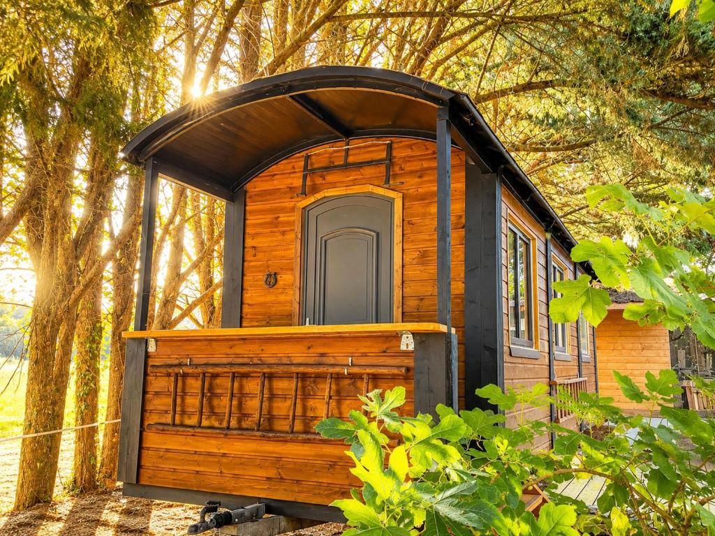 a wooden out house with a roof at Roulotte Cowboy - Tiny House insolite in Mignaloux-Beauvoir
