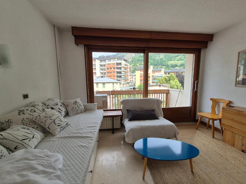 a living room with a couch and a chair and a window at Studio centre Bourg-Saint-Maurice in Bourg-Saint-Maurice