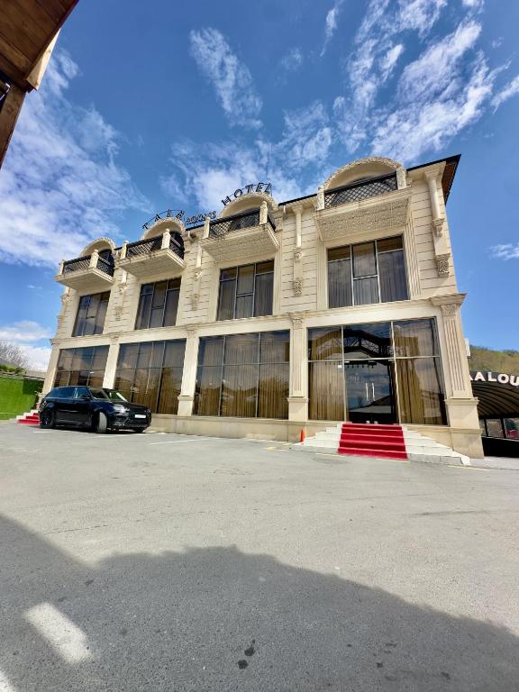 a building with a car parked in front of it at TALA ROOMS Hotel in Zaqatala