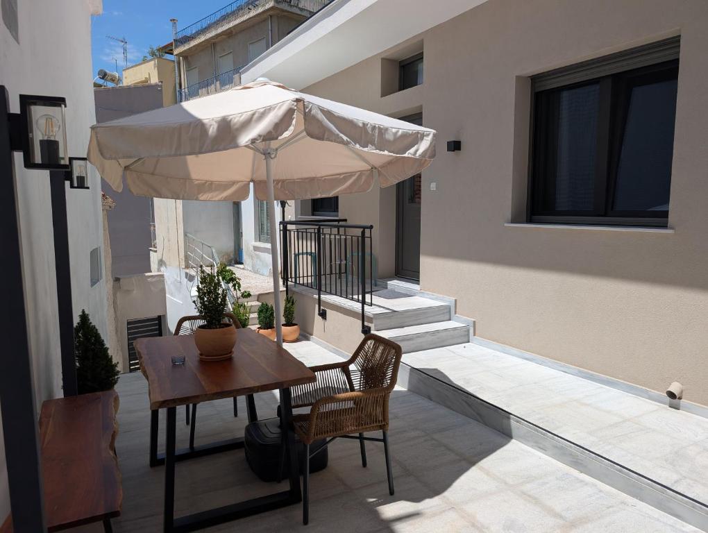 a patio with a table and an umbrella on a balcony at Ekavis House and Terrace in Kavála