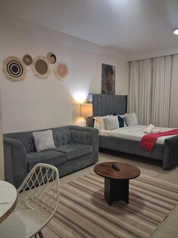 a living room with a couch and a bed at The Loftel in Ruaka