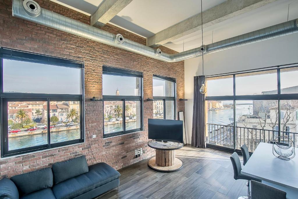 a living room with a couch and windows at Le Venise Factory in Martigues