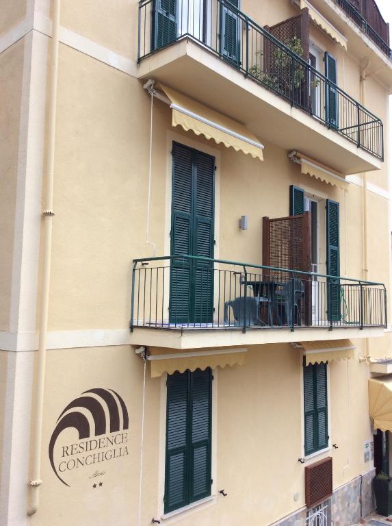 a building with a balcony and a sign on it at Residence Conchiglia Aparthotel in Alassio