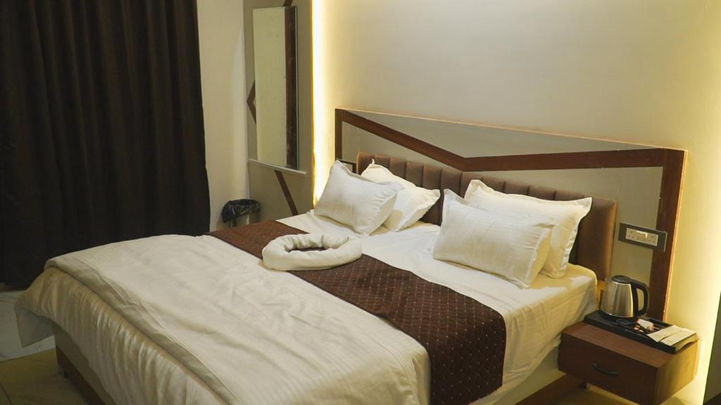 a hotel room with a large bed with white pillows at Shaahi Resort Harda in Bhunās