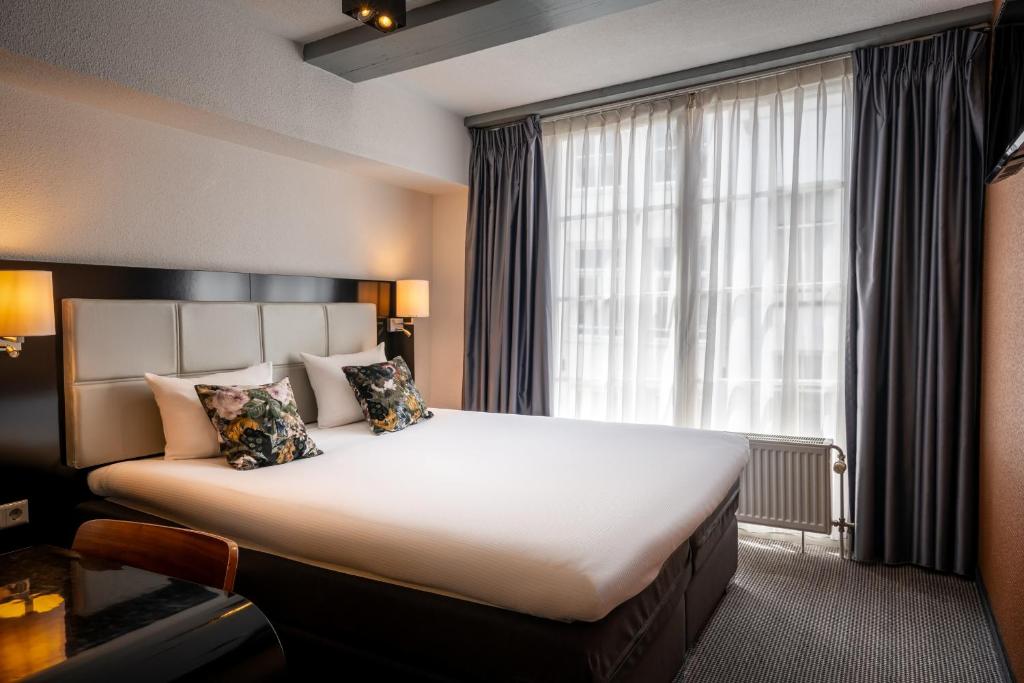 a hotel room with a large bed and a window at Hotel Mansion in Amsterdam