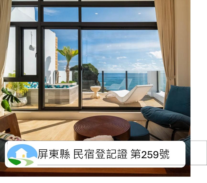 a living room with a large window with a view at 墾丁山海晴民宿 in Eluan
