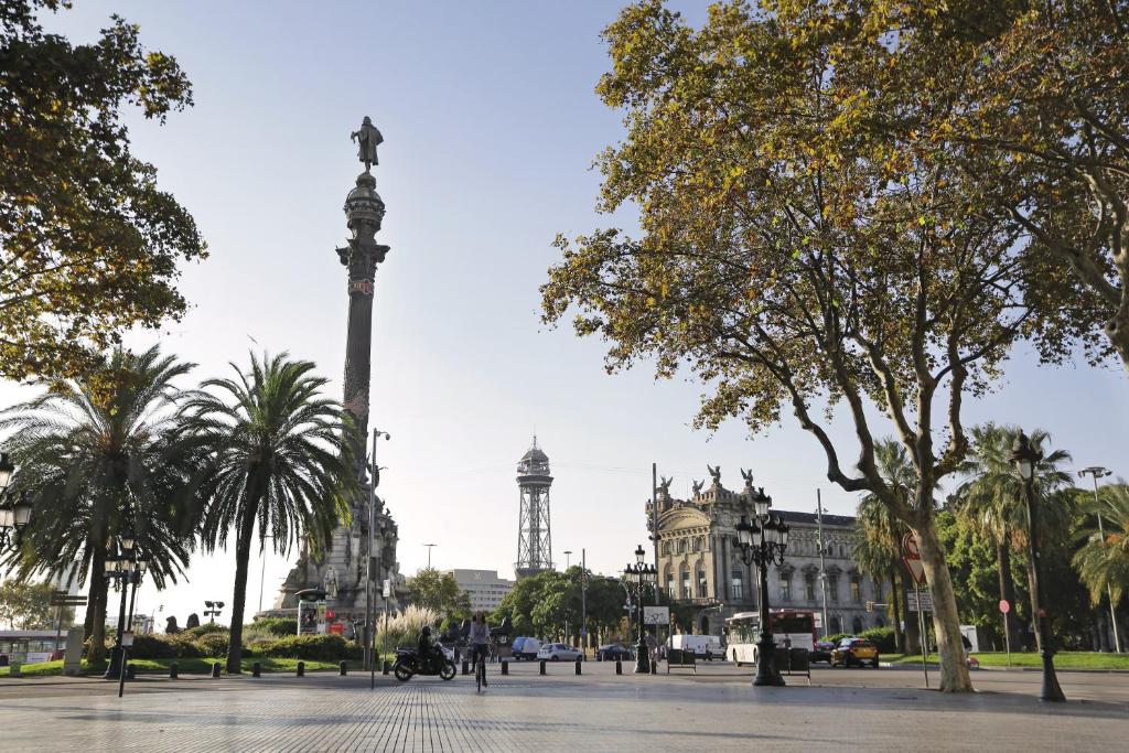 a city square with a tall pole in front of a building at Arc La Rambla in Barcelona