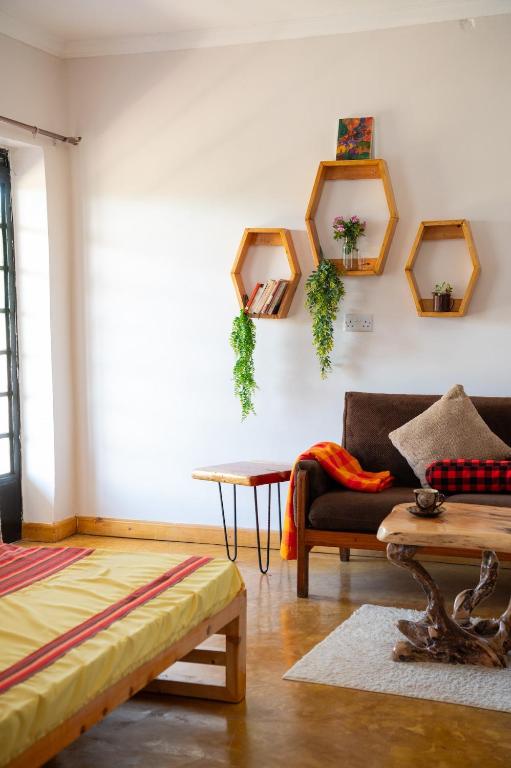 a living room with a couch and mirrors on the wall at Miti Retreat Nanyuki in Naro Moru