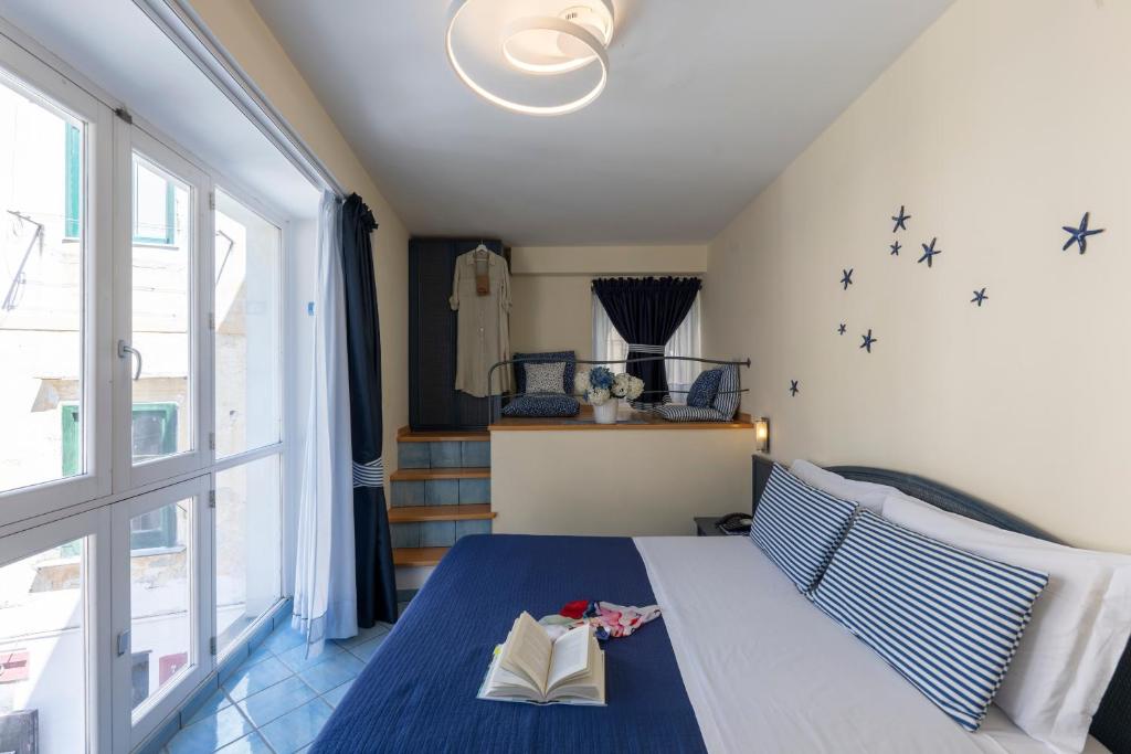 a bedroom with a bed with a book on it at Sharon House in Amalfi