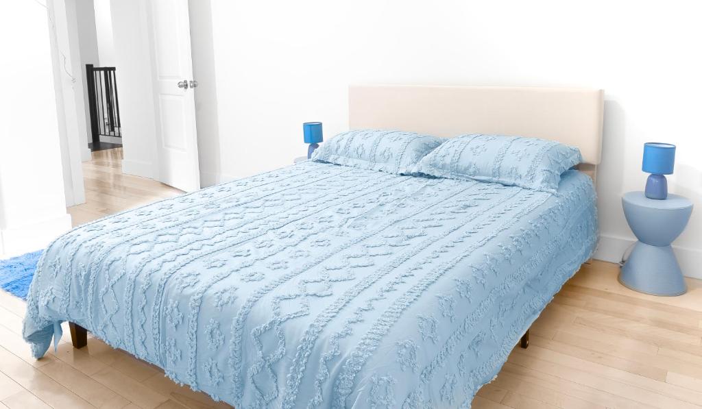 a bed with a blue comforter and two blue pillows at Beachh - 2Beach Home - Blue3090 in Brooklyn