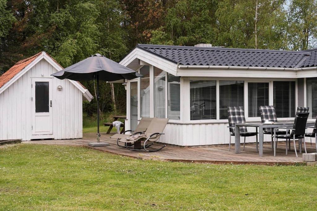 a house with a deck with a table and an umbrella at 0416-Romo-Dyssebjergvej-13 in Høm