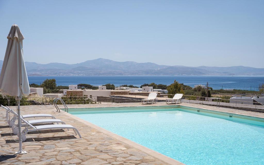 a swimming pool with two chairs and an umbrella at Villa Kohyli by Mediterà in Isterni