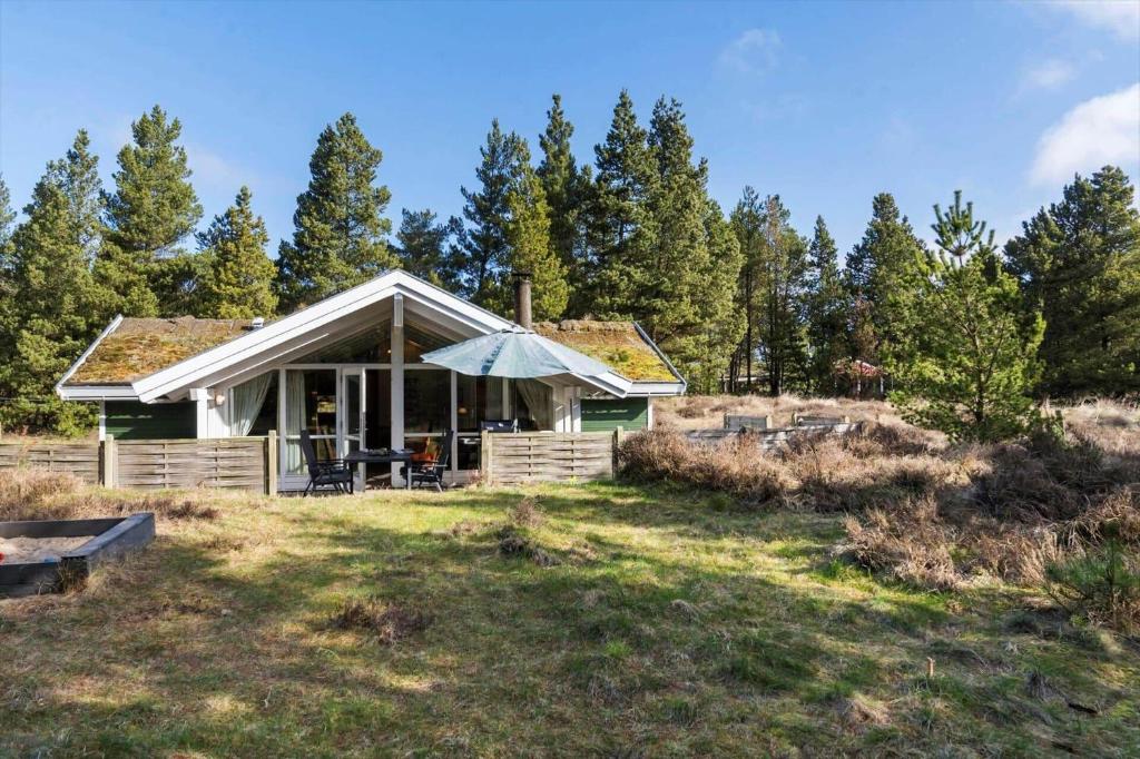 a small house on a hill with trees at 0046-Romo-Trinnesvej-17 in Høm