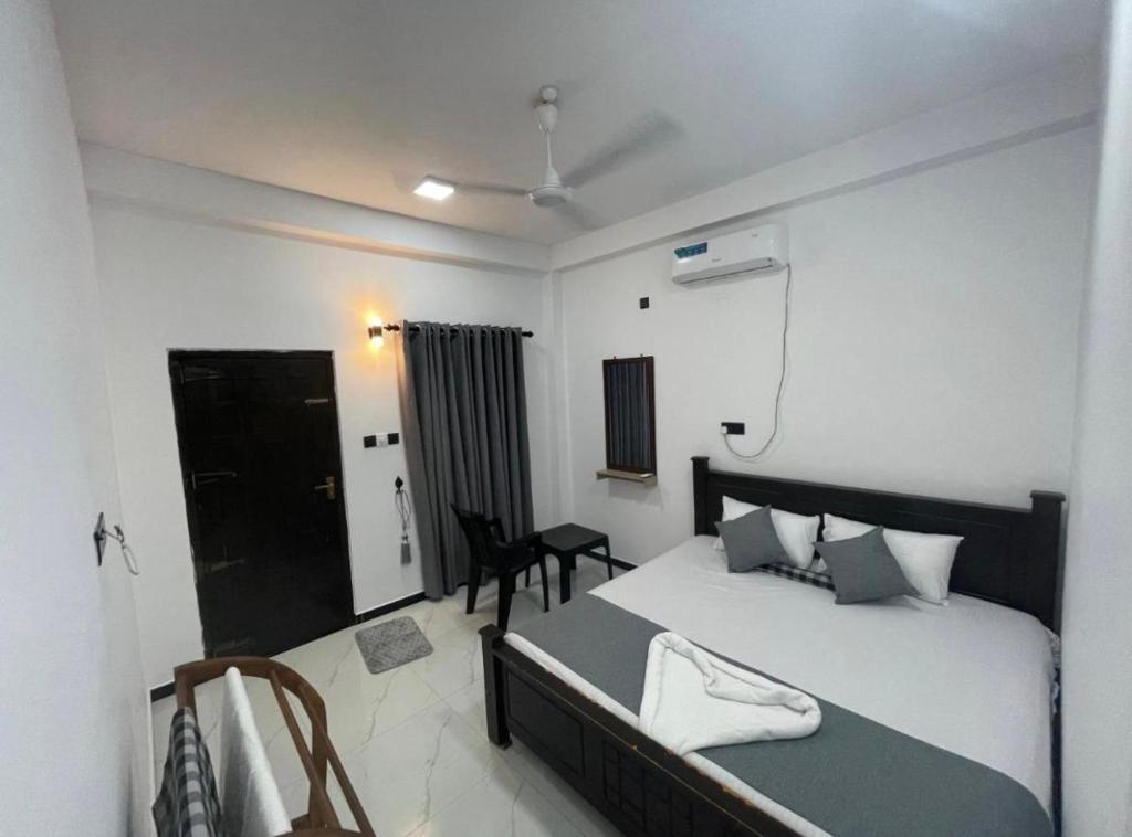 a bedroom with a bed and a desk in it at NRT Beach Hotel in Trincomalee