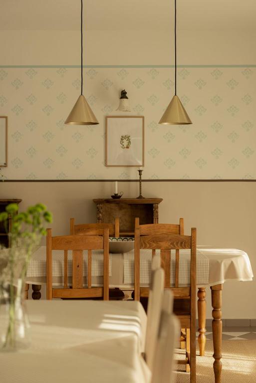 a dining room with a table and chairs and lights at Macskalépcsős Boutique B&B in Dörgicse