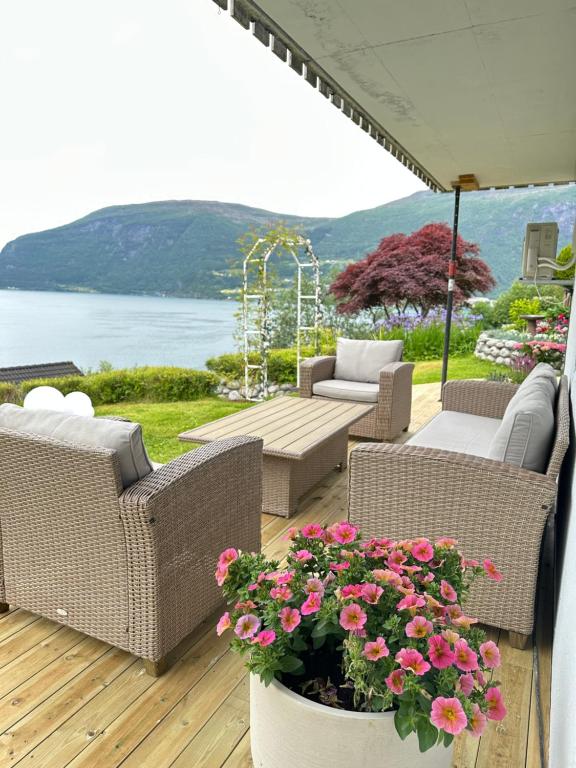 a patio with wicker chairs and a table and flowers at Villa Myklebust in Olden