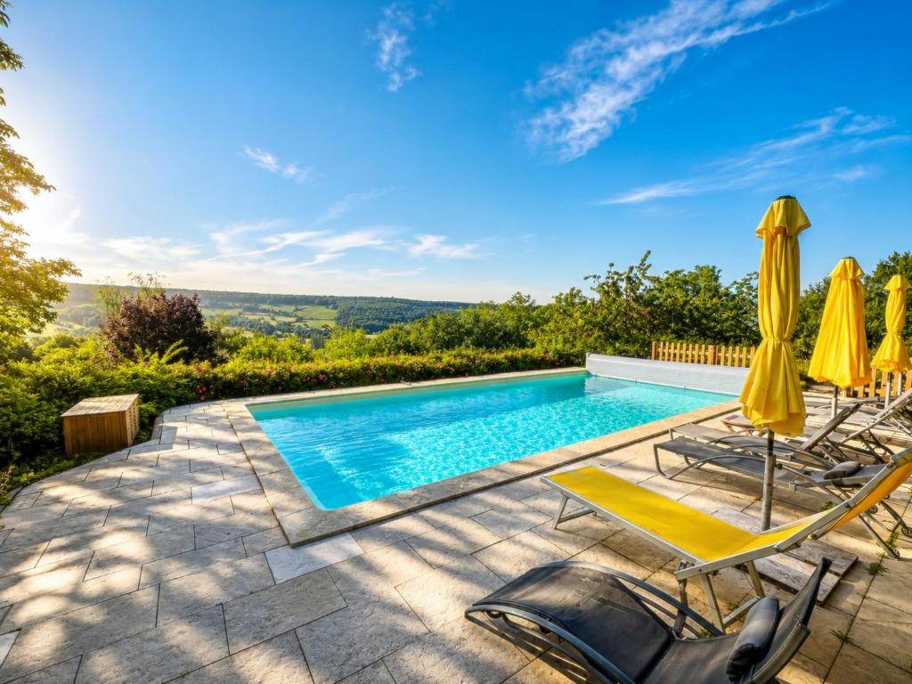 a pool with chairs and umbrellas on a patio at Clos de Fougères - La Grange 6-7 personnes in Montoillot
