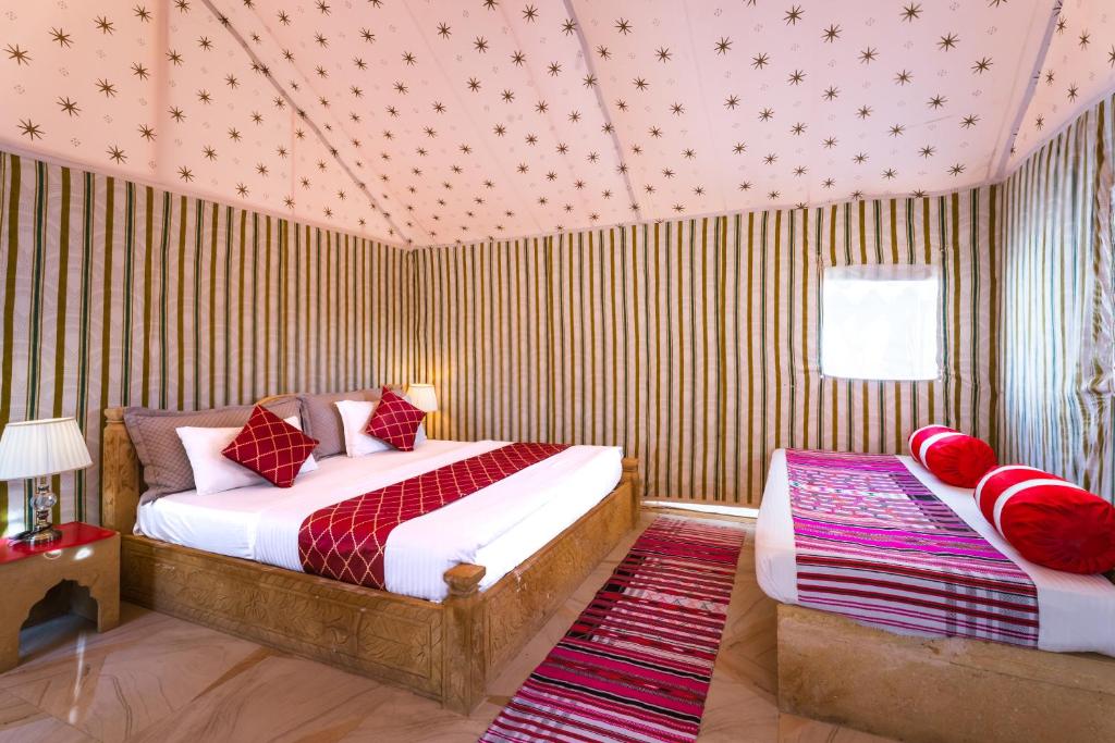 a bedroom with two beds in a room with striped walls at Rojani Resort in Sām