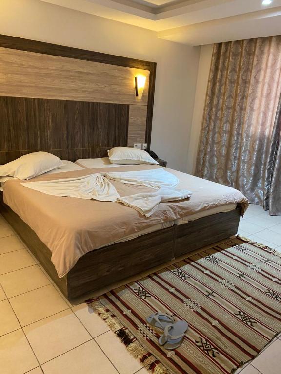 a bedroom with a large bed with a wooden headboard at Hôtel Matous in Tunis