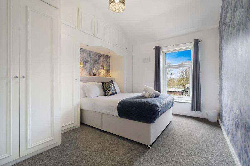a white bedroom with a bed and a window at Work Friendly 3 Bed House with Sofa Beds that Sleeps 7 in Fishburn