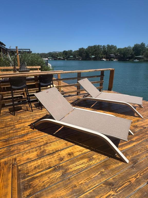 a couple of chairs sitting on a deck next to the water at Ada Bojana Kucica in Ulcinj