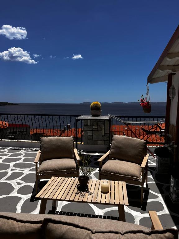 a patio with two chairs and a table on a balcony at Agape Studios in Neos Marmaras