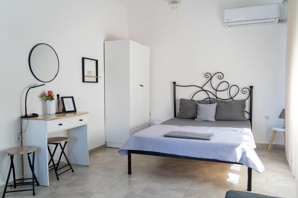 a bedroom with a bed and a desk with a mirror at Rodostagma 1 in Rodholívos