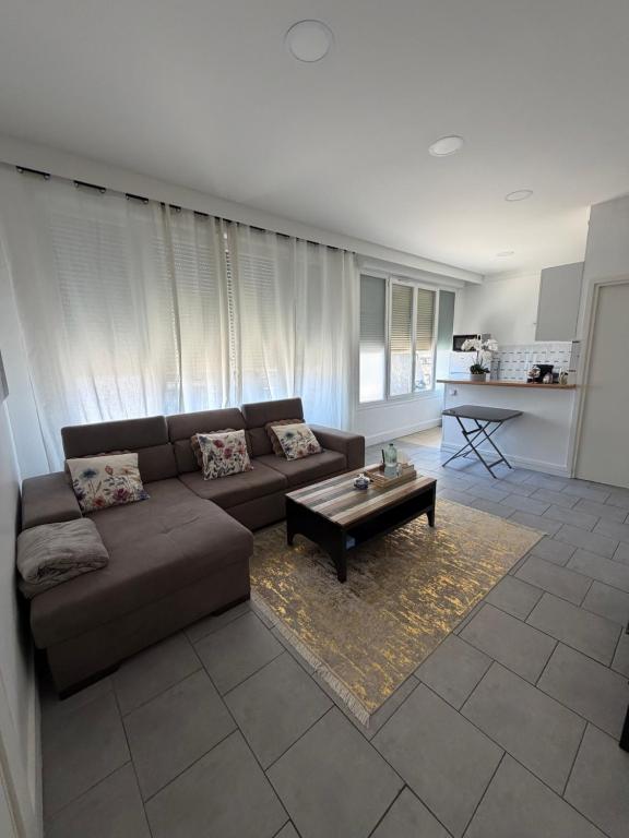 a living room with a couch and a coffee table at Spacieux et lumineux, coup de cœur garanti à proximité du métro et RER in La Courneuve