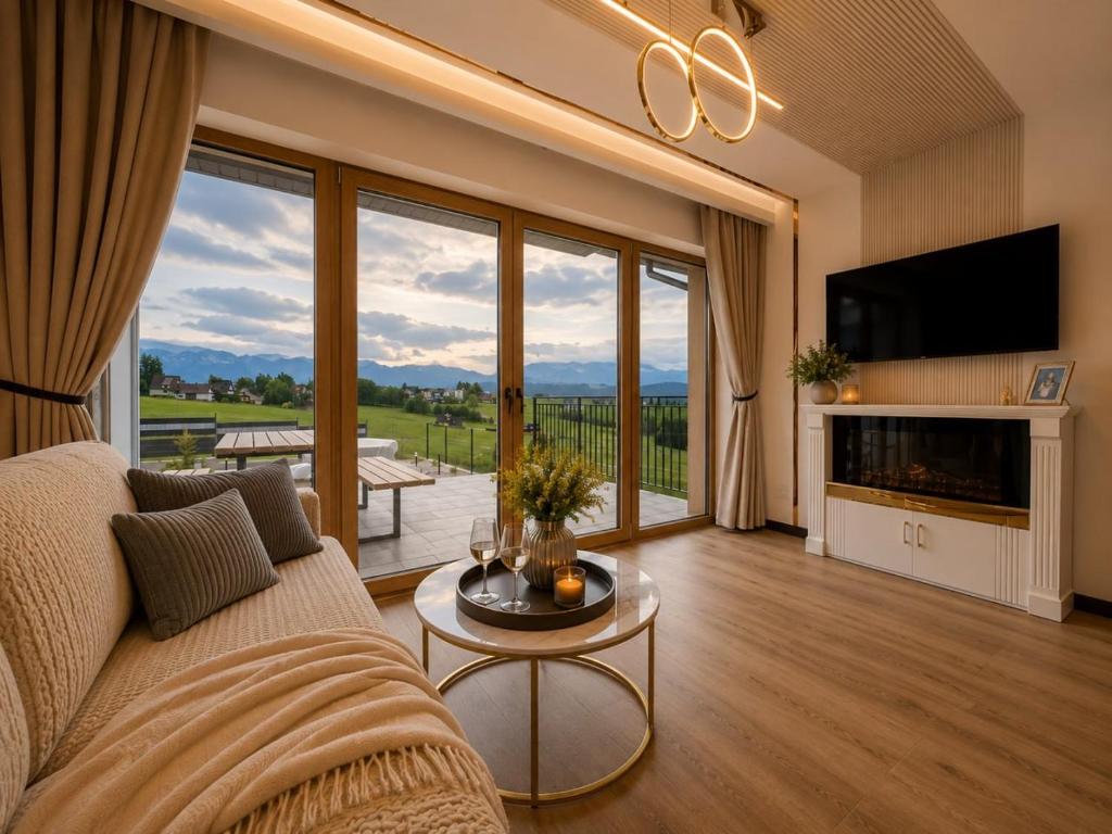 a living room with a couch and a large window at Golden Trio Villas in Ząb