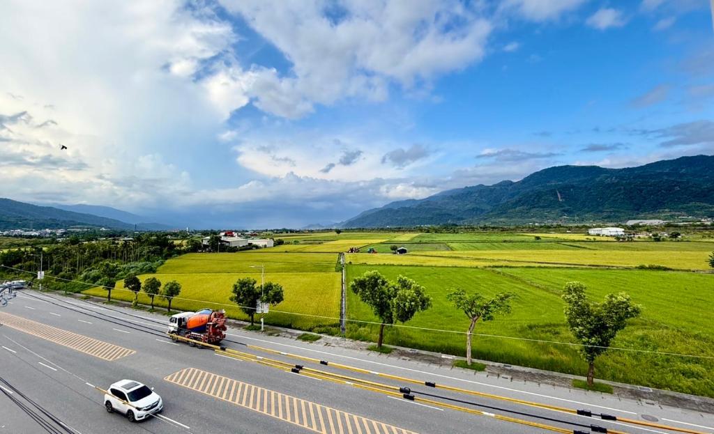 a truck driving down a highway with green fields at Green Home in Yuli