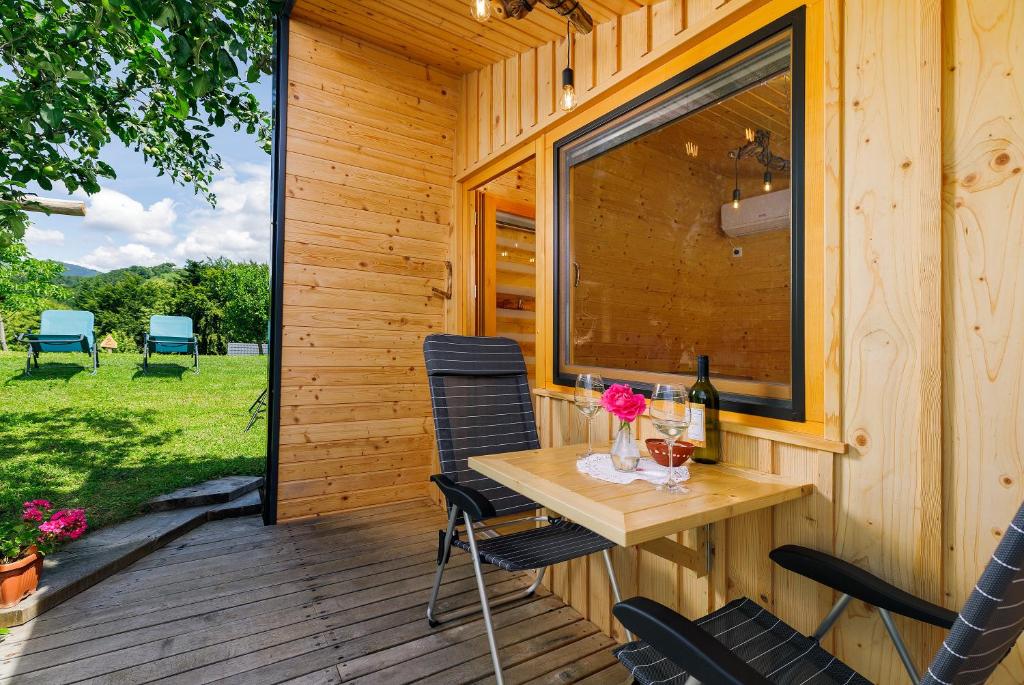 a wooden cabin with a table and chairs on a deck at Glamping Slavica in Dramlje