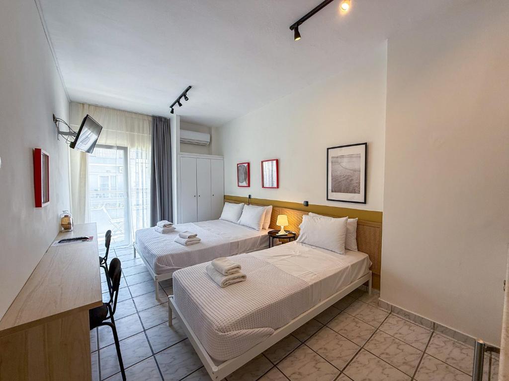 a hotel room with two beds and a desk at Seagull apartments - A in Paralia Katerinis