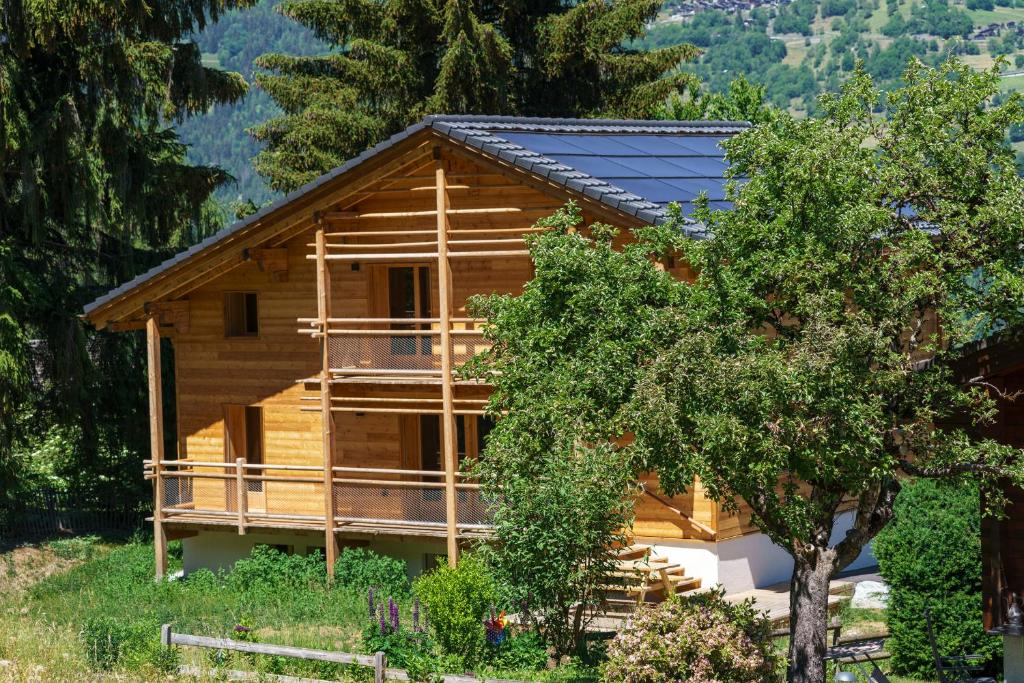 a log cabin with a tree in front of it at Chalet des Cheneaux in Bruson